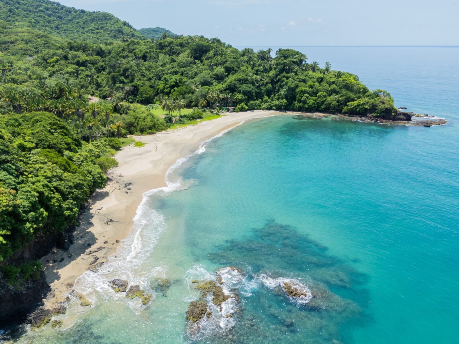 Crystal-clear,Turquoise,Waters,Lap,Against,A,Pristine,Sandy,Beach,,Surrounded